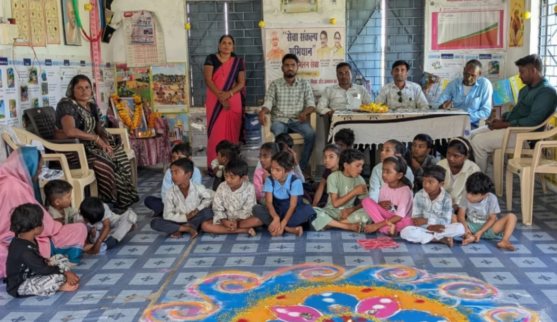 सुरपाला आंगनवाड़ी में सेवा संकल्प अभियान के तहत आंगन मिलन कार्यक्रम में अतिथियों के साथ बैठे बच्चे